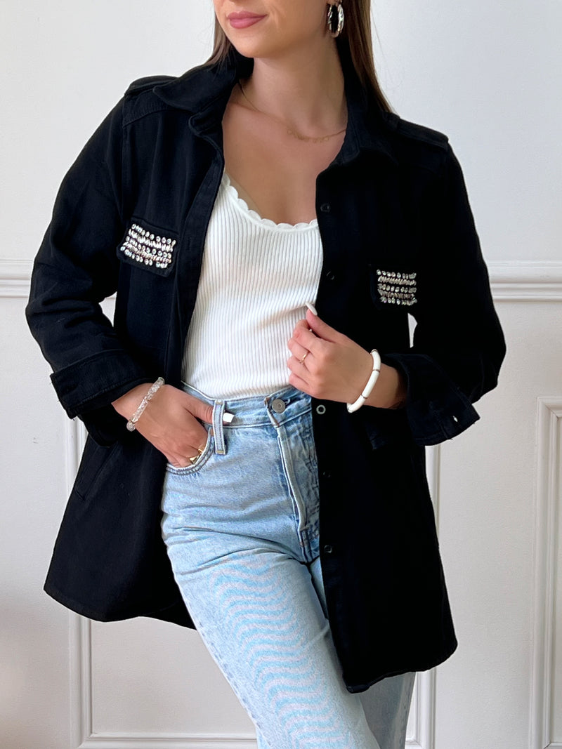 VESTE NOIRE EN COTON FEMME Veste manches longues Boutons sur la longueur et aux poignets 2 poches au niveau de la poitrine et 2 poches latérales à découdre Strass sur les poches à la poitrine Couleur : noir Composition : 100% Coton
