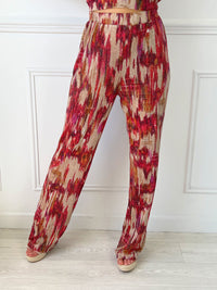 PANTALON FLUIDE À MOTIFS FEMME Pantalon fluide Élastique à la taille Couleur : beige avec motif rose, bordeaux et orange Composition : 100% Polyester