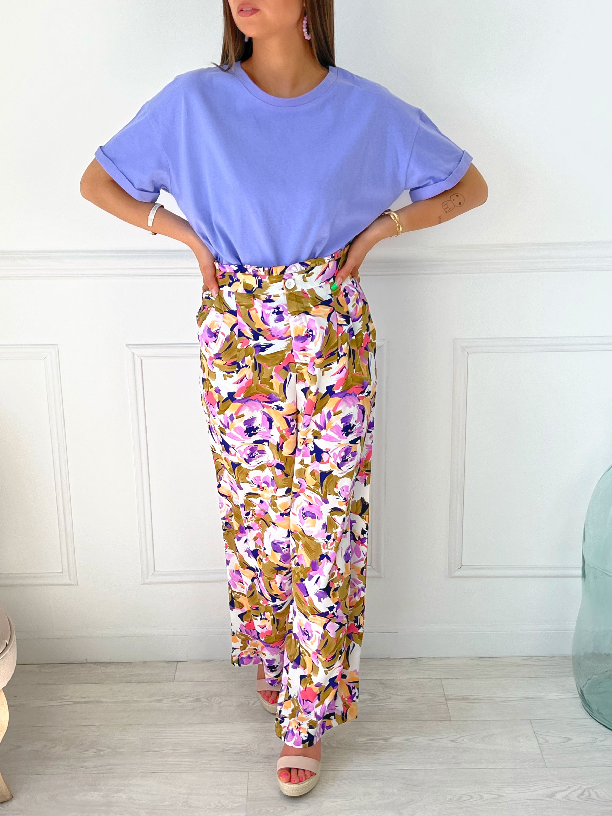 PANTALON FLUIDE À MOTIF FEMME Pantalon fluide Elastiqué à la taille Fermeture éclair et bouton Couleurs : écru, kaki, violet et rose Motif floral Composition : 100% Polyester
