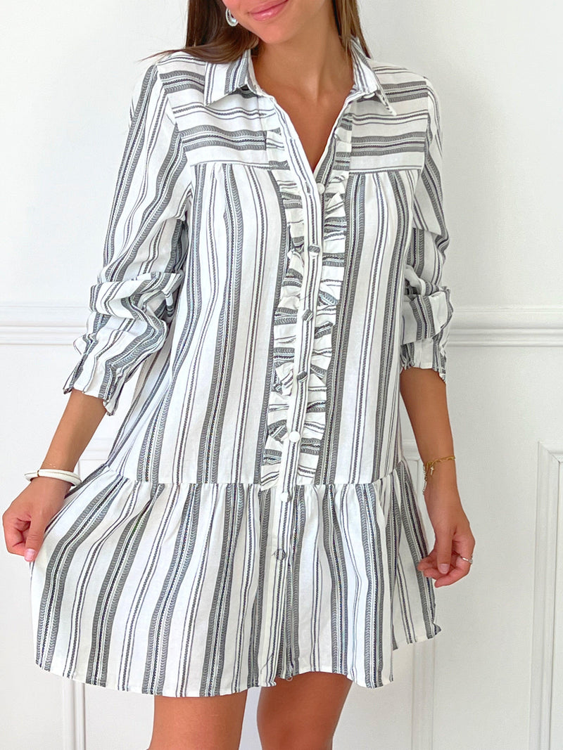 ROBE GRISE ET BLANCHE À VOLANTS Robe chemise Volants et boutons sur la longueur Col chemise Elastiquée aux poignets Coupe ample Motif rayure écrue et grise Couleurs : blanc et gris Composition : 60% Coton 30% Viscose Lavage à la main