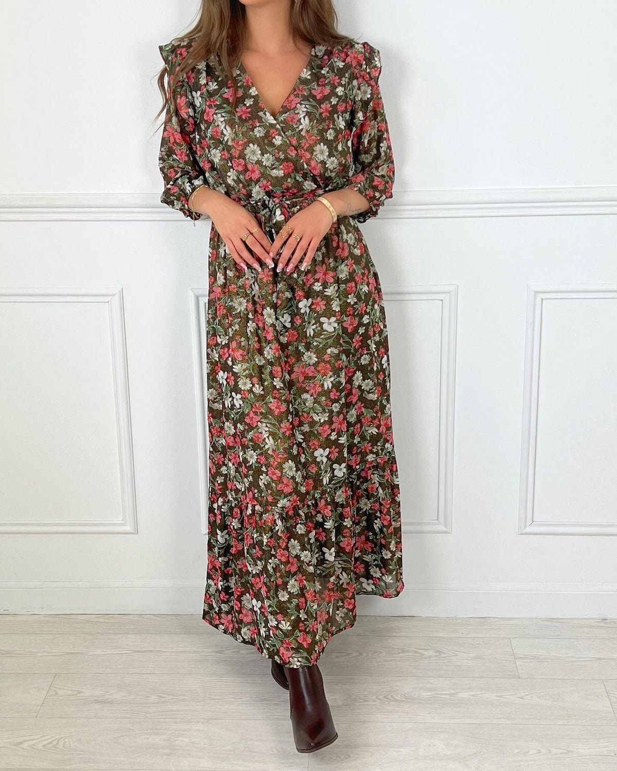 ROBE LONGUE CACHE COEUR Robe manches 3/4 Col cache cœur Elastique à la taille avec une ceinture amovible Doublée sauf sur les manches Volants sur les épaules Couleurs : rose, écru, vert et noir avec détails dorés Motif fleuri Composition : 60% Polyester, 40% Viscose Lavage à la main obligatoire
