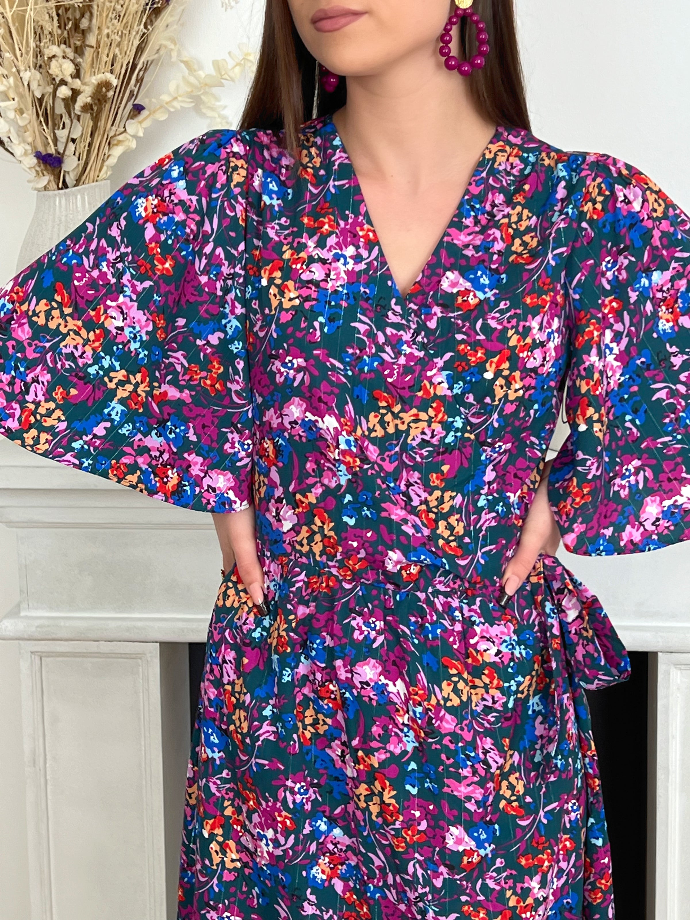 ROBE PORTEFEUILLE À MANCHES COURTES Robe courte à manches courtes Col cache-cœur Fils lurex argentés Coupe portefeuille Fleurie Couleurs : vert, violet, rouge, bleu, orange Composition : 100% Polyester Lavage à la main obligatoire