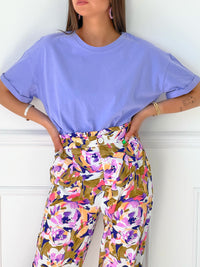 PANTALON FLUIDE À MOTIF FEMME Pantalon fluide Elastiqué à la taille Fermeture éclair et bouton Couleurs : écru, kaki, violet et rose Motif floral Composition : 100% Polyester