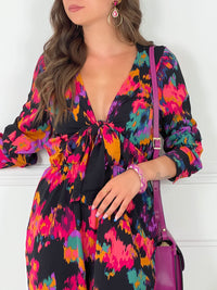 COMBINAISON COLORÉE Combinaison à manches longues Col V plongeant avec lien de serrage réglable Taille élastiquée Couleurs : imprimé vert violet rose sur fond noir Composition : 100% Polyester Lavage à la main conseillé
