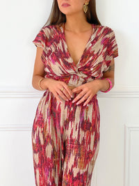 TOP FEMME SANS MANCHES PAILLETE  Top sans manches Col V devant Effet croisé sur le devant Pailleté sur tout le top Couleur : beige avec motifs rose, bordeaux, orange Matière légèrement extensible Elastique à l’arrière de la taille
