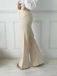 JEAN FLARE BEIGE TAILLE HAUTE FEMME Jean flare Taille haute Fermeture boutons et zip Passants pour ceinture 2 poches à l’avant, 2 poches à l’arrière Couleur : beige Composition : 98,5% Coton, 1,5% Elasthanne