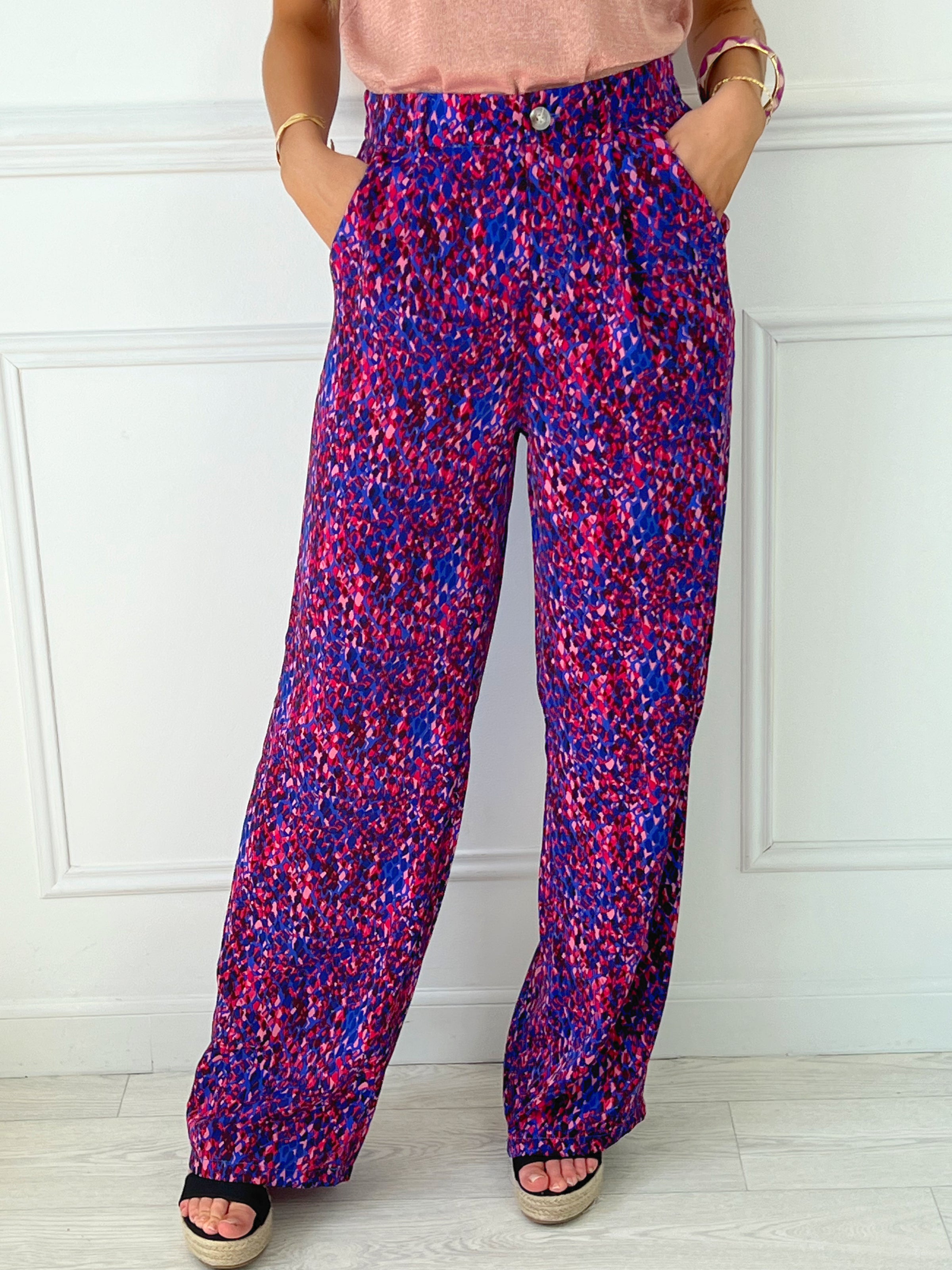 PANTALON FLUIDE FEMME VIOLET ET ROSE Pantalon fluide Élastique au dos Passants pour ceinture Fermeture éclair et bouton Couleurs : violet et rose 2 poches latérales Composition : 100% Polyester