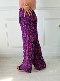 PANTALON FLUIDE FEMME VIOLET ET ROSE Pantalon fluide Élastique au dos Passants pour ceinture Fermeture éclair et bouton Couleurs : violet et rose 2 poches latérales Composition : 100% Polyester