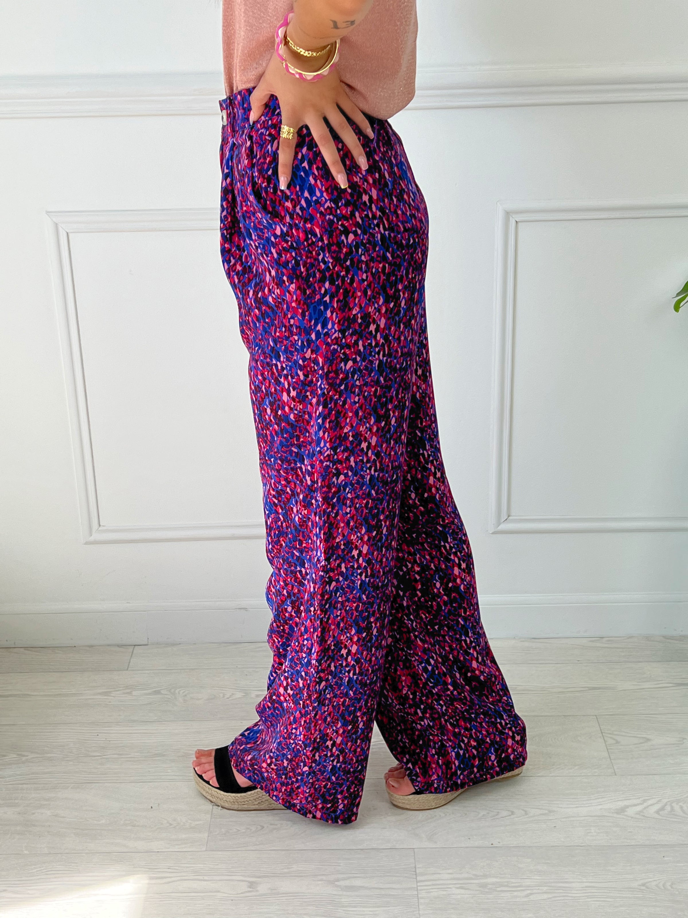 PANTALON FLUIDE FEMME VIOLET ET ROSE Pantalon fluide Élastique au dos Passants pour ceinture Fermeture éclair et bouton Couleurs : violet et rose 2 poches latérales Composition : 100% Polyester